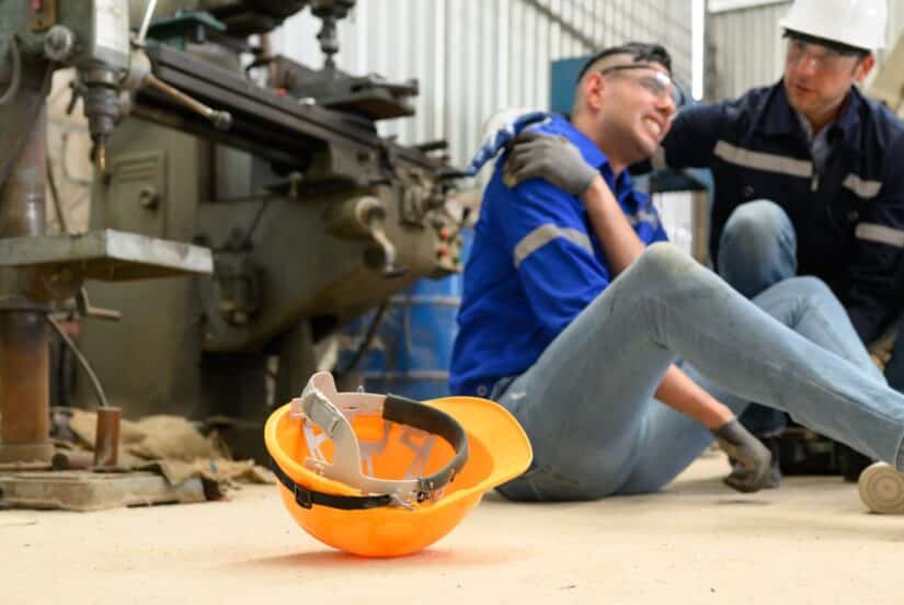 Worker injured in machinery accident at workplace receiving assistance while highlighting workers compensation claim process and legal rights